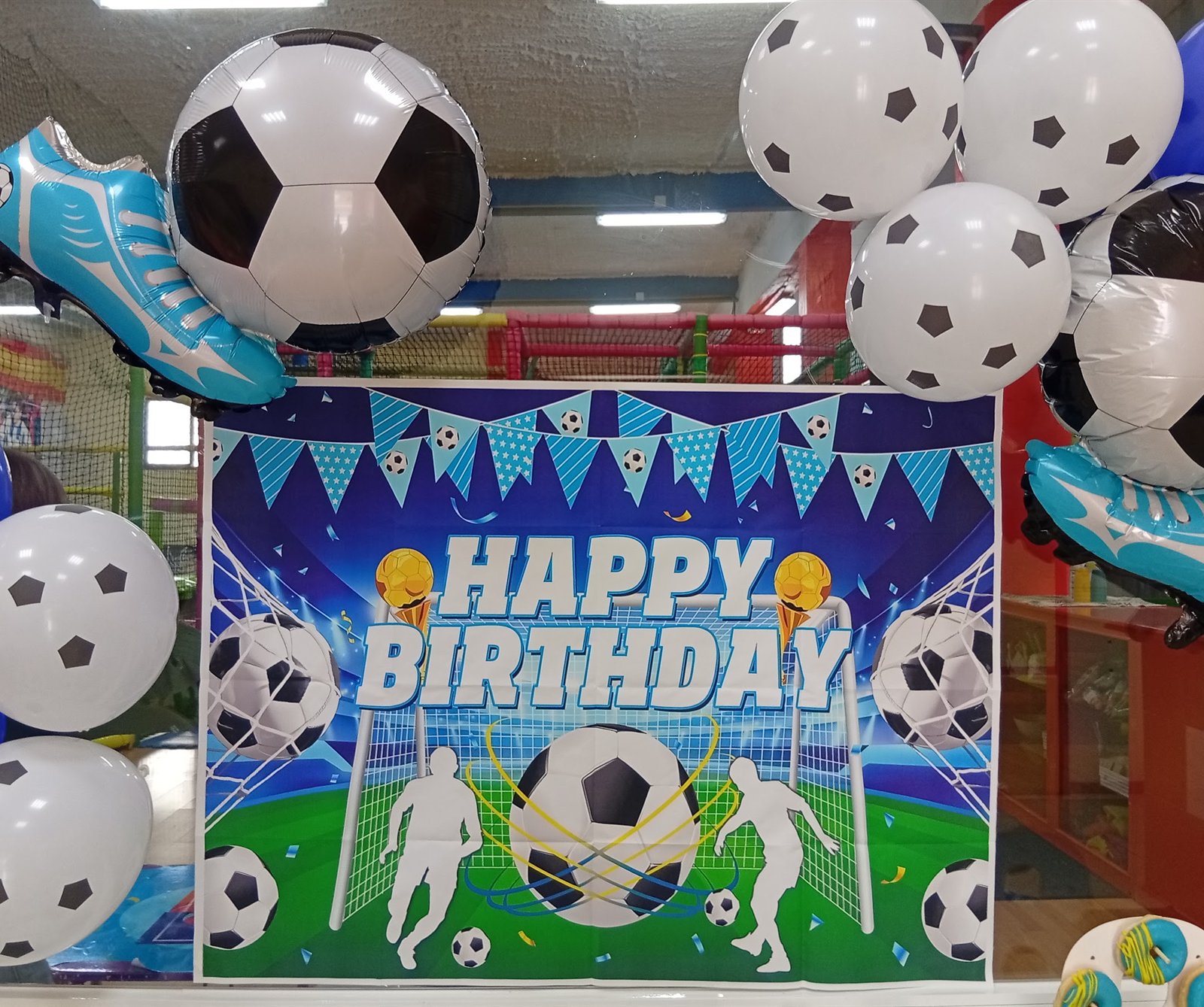 Decoración de cumpleaños temático de fútbol con globos de balones y cartel de Happy Birthday en diverpark
